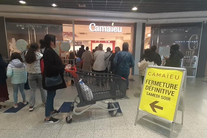 Vitrines de magasins dans un centre-ville français touché par la concurrence du commerce en ligne.